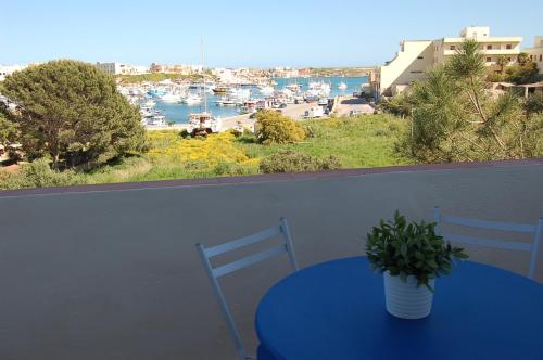 einem blauen Tisch mit Topfpflanze auf dem Balkon in der Unterkunft Case Vacanze Farchikalà in Lampedusa