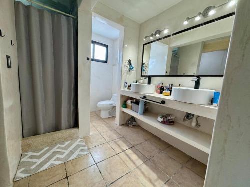 a bathroom with two sinks and a shower and a mirror at Casa Baja, with Gym & Terraces in La Paz