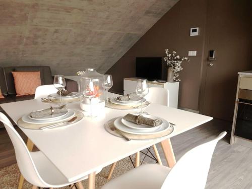 a white dining room table with white chairs and glasses at Innapartments - São Gonçalinho in Aveiro