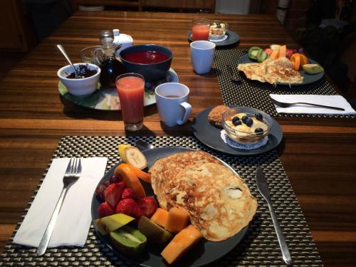 a wooden table with plates of breakfast food on it at Gite L'Imprévu in Montréal