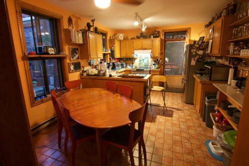 a kitchen with a wooden table and chairs in it at Gite L'Imprévu in Montréal