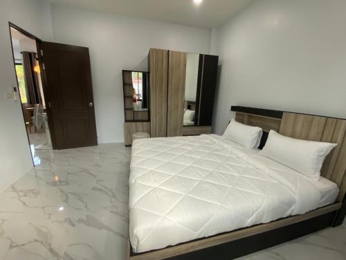 a bedroom with a white bed and a mirror at Cozy Palm Hills in Ban Nong Thale