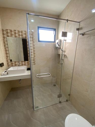 a bathroom with a shower and a toilet and a sink at Cozy Palm Hills in Ban Nong Thale