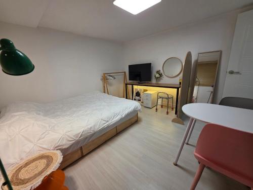 a bedroom with a bed and a desk and a table at dalcom kunkuk in Seoul