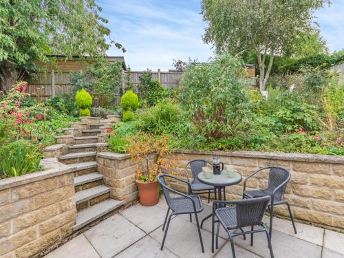 a patio with a table and chairs in a garden at Cherry Tree Corner in Ashbourne