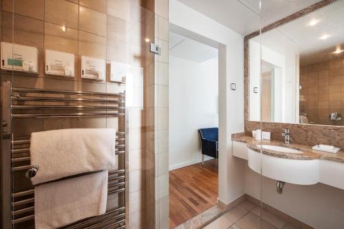 een badkamer met een wastafel en een spiegel bij Kurhotel Skodsborg in Skodsborg