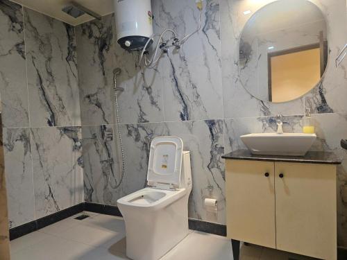 a bathroom with a toilet and a sink at Shahenshah Hotel in Civil Lines, Prayagraj in Prayagraj