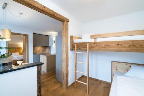 a bedroom with a bunk bed and a kitchen at Appartement Wiederkehr in Flachau