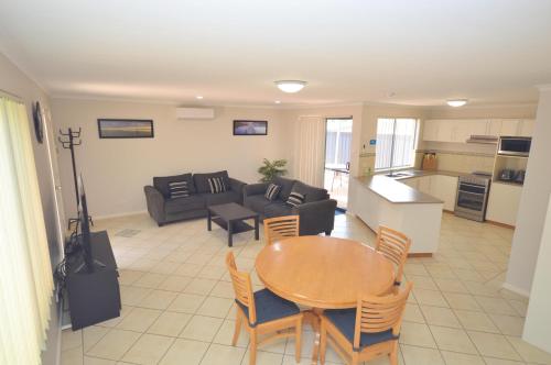 a living room with a table and a kitchen at Blue Ocean Villa 7 - Kalbarri, WA in Kalbarri