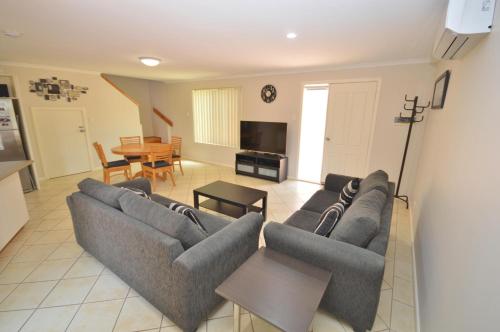 a living room with two couches and a table at Blue Ocean Villa 7 - Kalbarri, WA in Kalbarri