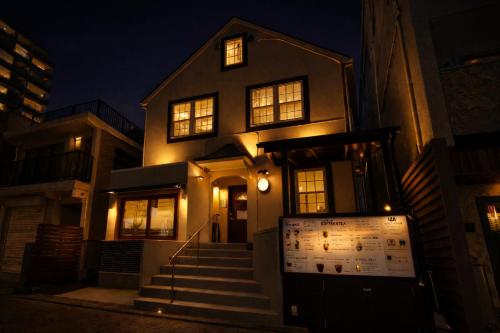 a house with a sign in front of it at night at IZA Enoshima Guest House in Fujisawa