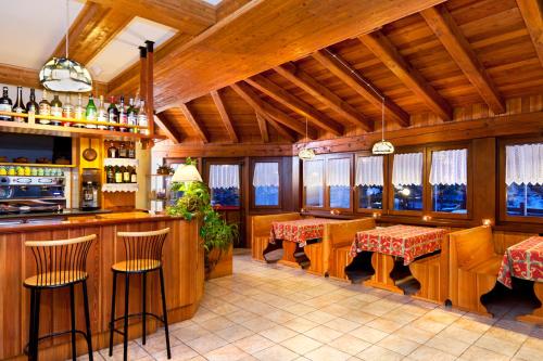 un restaurante con un bar con mesas y sillas en Hotel Beau Site, en Brusson