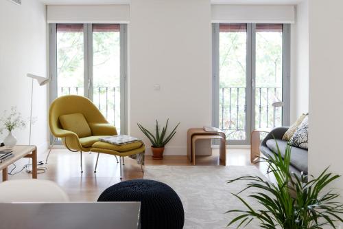 a living room with a yellow chair and a couch at 60 Balconies Art in Madrid