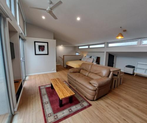 a living room with a couch and a bed at Studio Apartment close to the CBD in Unley