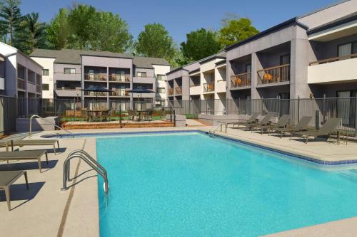 a swimming pool at a hotel with chairs and a building at Courtyard by Marriott Birmingham Homewood in Birmingham