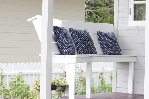 a white bench with pillows on a porch at Terrua Main Ten Villa Garden in Suan Phung