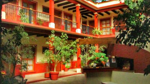 a building with a bunch of potted plants on it at Hotel Real del Valle in San Cristóbal de Las Casas