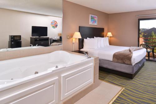 a hotel room with a large tub and a bed at Atlantis Family Waterpark Hotel, an Ascend Collection Hotel in Wisconsin Dells
