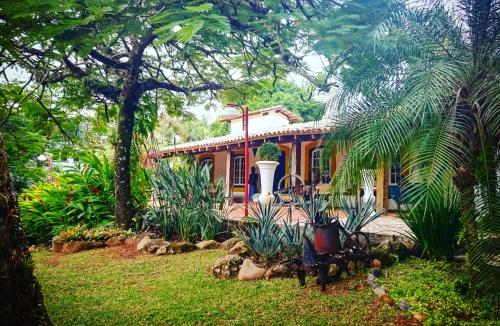 une maison avec un jardin en face dans l'établissement Ilhabela Homestay, à Ilhabela