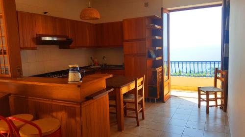 una cucina con bancone e vista sull'oceano di Appartamento Torre a Ioppolo