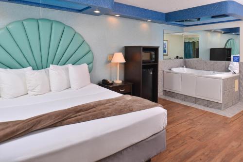 a bedroom with a bed and a bathtub and a bed and bathroom at Atlantis Family Waterpark Hotel, an Ascend Collection Hotel in Wisconsin Dells