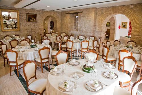 a banquet hall with white tables and chairs at Hotel Castello di Septe in Mozzagrogna