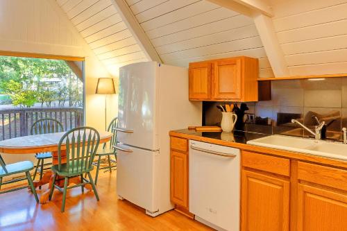 a kitchen with a white refrigerator and a table with chairs at Jupiter Landing in Hoodsport
