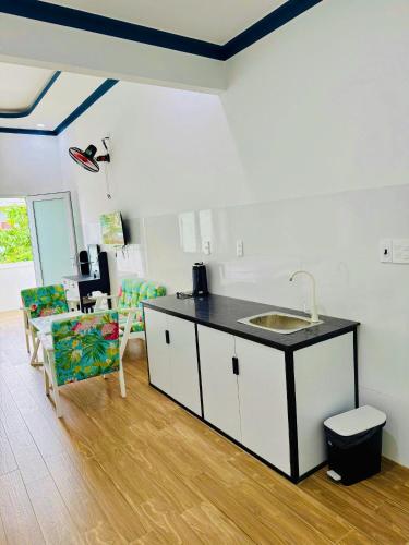 a kitchen with a sink and a counter with chairs at Hotel 86 in Phan Thiet