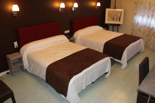 a hotel room with two beds and a table at Hôtel Saint-Hubert in Saint-Claude