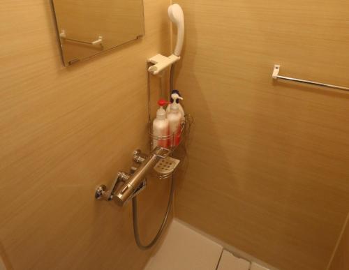 a shower in a bathroom with a hose attached to a wall at ゑびすや in Kofu