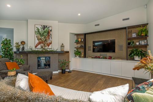 a living room with a couch and a tv at Riverside Retreat Entire home in Palmerston North
