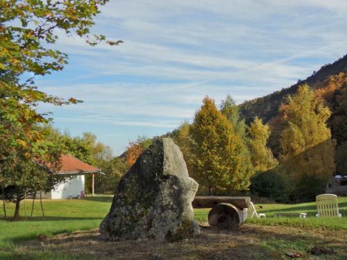 a large rock in a park with a bench at Hotel-Spa & Restaurant Logis Domaine Langmatt in Murbach
