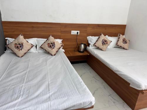 two beds sitting next to each other in a room at Gajanand Homestay in Ujjain
