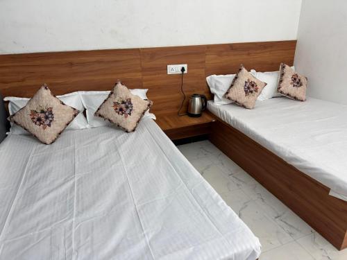 two beds sitting next to each other in a room at Gajanand Homestay in Ujjain