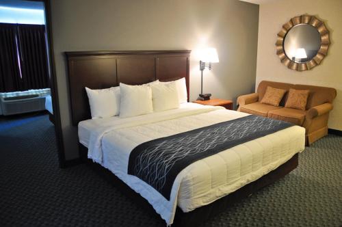 a hotel room with a large bed and a chair at Dunes Express Inn and Suites in Hart