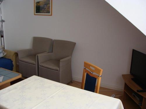 a living room with a couch and a television at Hotel Löhr in Baden-Baden