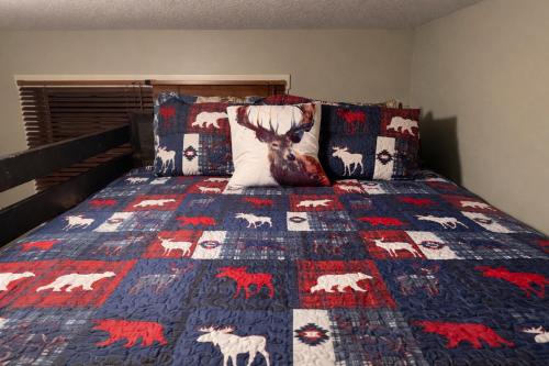 a bed with a quilt with animals on it at Summit View Alpine Retreat in Radium Hot Springs
