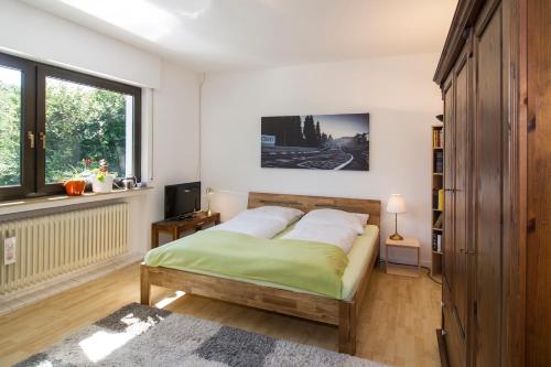 Schlafzimmer mit einem Bett, einem TV und einem Fenster in der Unterkunft Ferienhaus Faltmann in Heimbach