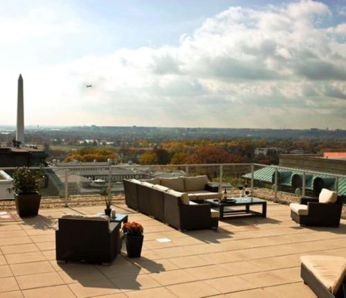 a patio with couches and tables on a roof at Global Luxury Suites at The White House in Washington