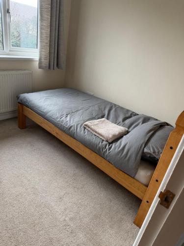 a bed in a room with a gray blanket on it at 2 Bed Fully Furnished House In Milford Haven in Milford Haven