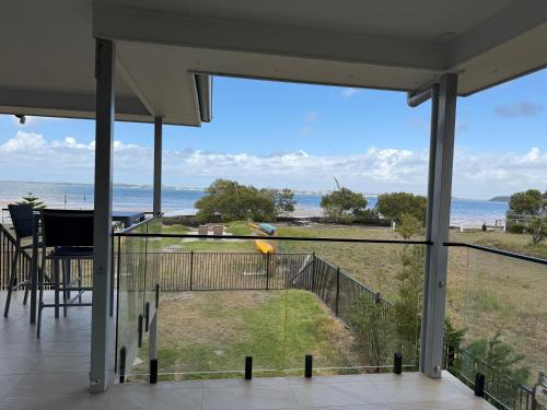 a bird on a balcony with a view of the ocean at ABSOLUTE BEACHFRONT Port Stephens - Pindimar Beach House in Pindimar