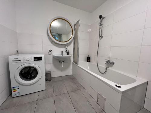 a white bathroom with a washing machine and a sink at Brilliant Souterrain Apt - Prter Amuesement Park in Vienna