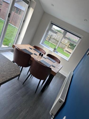 a dining room with a table and some windows at 2 Bed Fully Furnished House In Milford Haven in Milford Haven