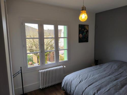 a bedroom with a bed and a large window at Chez Marine & Justine in Charolles