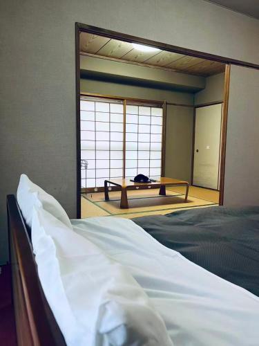 a bedroom with a bed and a large window at 紀州鉄道草津温泉ビラ in Kusatsu
