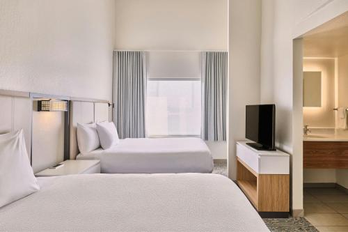 a hotel room with two beds and a television at SpringHill Suites Phoenix Glendale/Peoria in Peoria