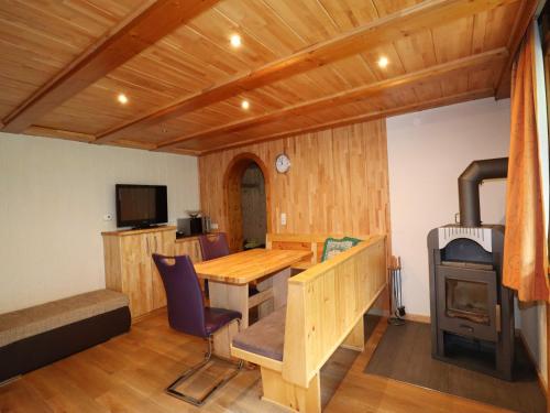 a room with a wooden table and a wood stove at Wohnung in Silbertal nahe Skilift in Silbertal
