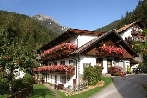 a house with flowers on the side of it at KASSNHOF - Urlaub in den Bergen in Telfes im Stubai