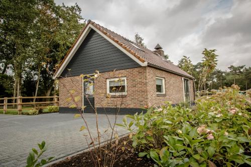 a brick house with a window in a yard at Het kleine Landgoed in Haarle