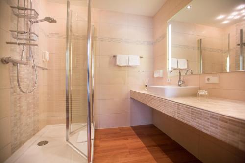 a bathroom with a shower and a sink at Flair Hotel Adlerbad in Bad Peterstal